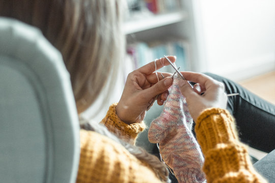 Junge Frau strickt eine Socke