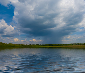dramatic dense rainy clouds  reflected in a water, thunderstorm on the lake