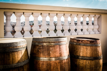 A Tunisian rooftop with old barrels in the foreground and Tunisian pillars in the background.