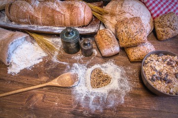 Bread and flour on a rustic wooden table.