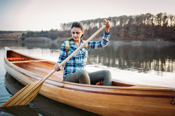 Travel woman paddling the canoe on the lake