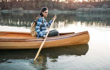 Young woman paddling canoe