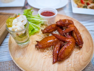 Grilled chicken wings with tomato sauce on the table in restaurant.Thai food style.
