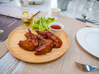 Grilled chicken wings with tomato sauce on the table in restaurant.Thai food style.