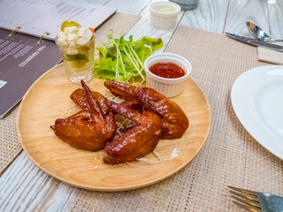 Grilled chicken wings with tomato sauce on the table in restaurant.Thai food style.