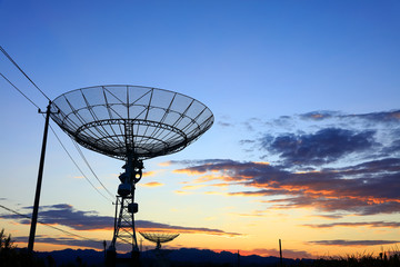 The silhouette of a radio telescope