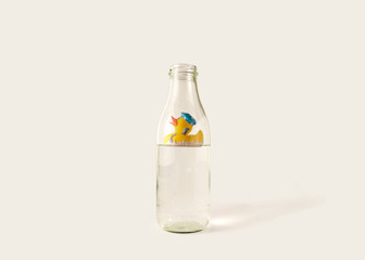 A yellow plastic duck floats in a water bottle.