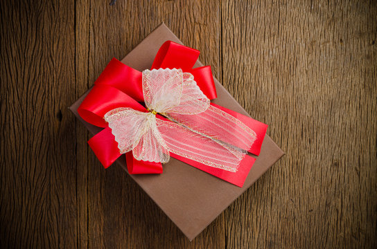 Brown gift box with white and red bow