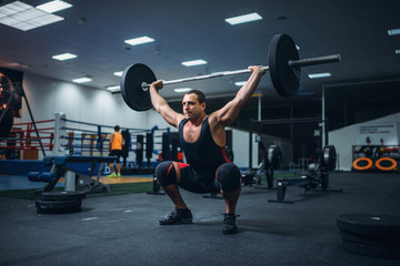 Strong powerlifter doing deadlift a barbell in gym