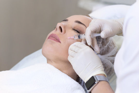CLose-up of mesotherapy in neck area in cosmetology clinic. Cosmetologist doing hyaluronic acid injection to keep woman skin young. Hardware cosmetology
