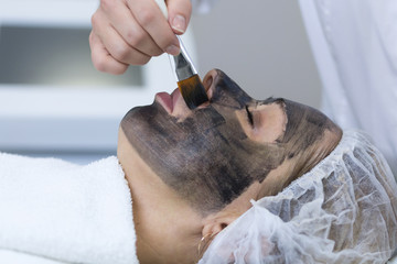 Close-up of carbon peeling procedure for middle-aged woman face. Laser pulses clean skin. Process...