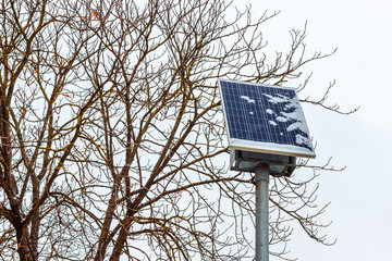 The snow-covered photovoltaic solar panel at the winter blizzard time. The problem of the solar power generation in north countries concept
