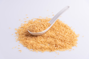 Raw Brown Rice on white background. Integral Wholegrain. Latin term Oryza sativa also known as Whole Chinese Rice seed