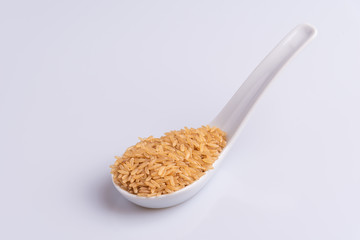 Raw Brown Rice on white background. Integral Wholegrain. Latin term Oryza sativa also known as Whole Chinese Rice seed