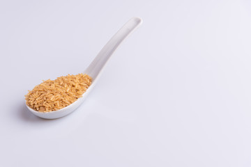 Raw Brown Rice on white background. Integral Wholegrain. Latin term Oryza sativa also known as Whole Chinese Rice seed