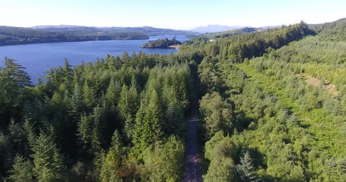 Inspiring Distant Green Landscape Drone Shot in Scotland with a Loch