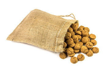 Traditional pepernoten treats in jute bag on white background