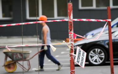 01.08.2018. минск. строительство. строитель, рабочий, тачка, ограждение, знак "осторожно опасная зона".