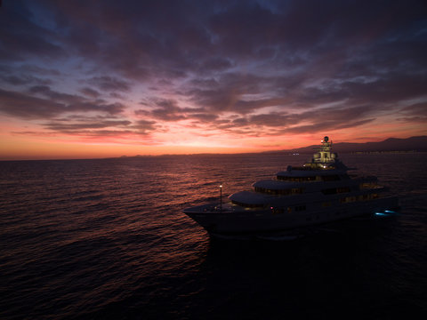 A huge luxury motor yacht underway on the sunset