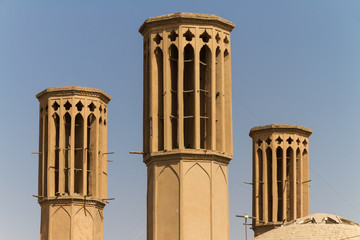 Iconic Badgirs (windtowers) in the mud-brick desert city of Yazd, Iran. An ancient rooftop air conditioning system that captures the wind for cooling the houses below.