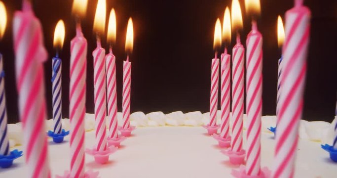 Super slide shot between the candles of a birthday cake, the camera goes really close to them. Concept: macro, party, holiday, dessert
