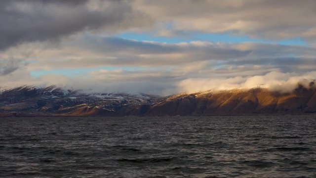 Daytime Timelapse of moving clouds over lake Sevan on background hills
