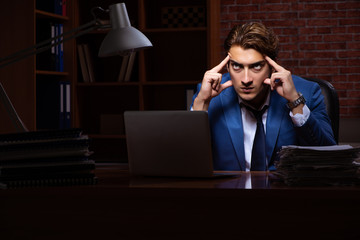 Young businessman working in the office at night 