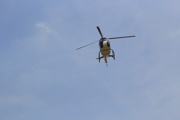 helicopter in flight on blue sky blackground