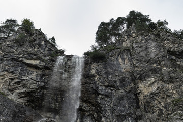 Fototapeta na wymiar High waterfall with rocks around