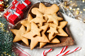 Merry Christmas and happy New year. Cookies, gifts and fir-tree branches on a wooden table. Selective focus. Christmas background.
