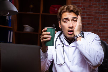 Young handsome doctor working night time at the hospital 