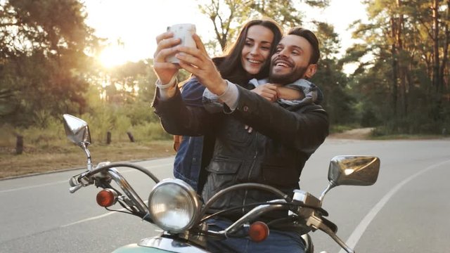 Couple on a scooter make instant selphie photos.