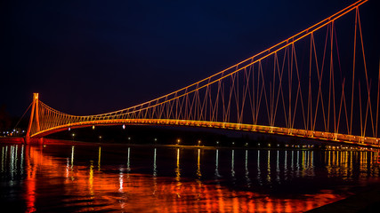 Side view of a colorful modern pedestrian bridge. Night in Osijek, Croatia.