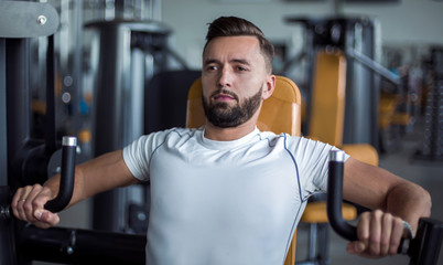 young man does weight training in the gym