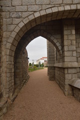 Arch Of Half Point In The Garden With Three Angels Background Of The Episcopal Palace In Astorga. Architecture, History, Camino De Santiago, Travel, Street Photography. November 1, 2018. Spain.