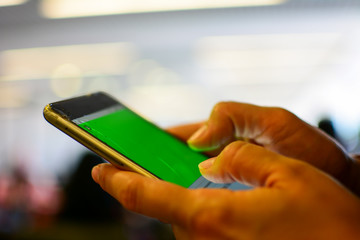 Women's hands use a green screen mobile phone. The hands touch the touch screen with a large aperture.