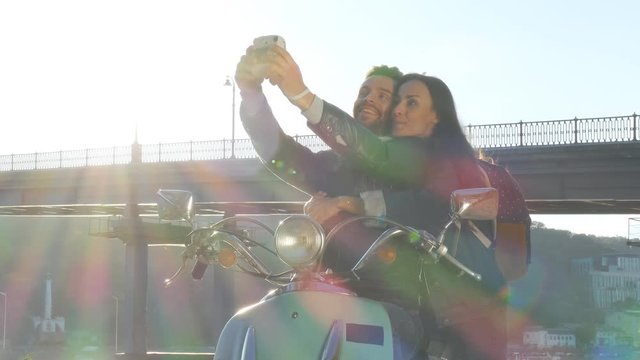 Couple on a scooter make instant selphie photos.