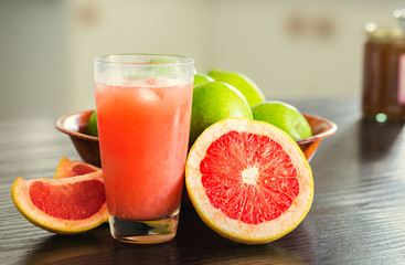 Naklejka na ściany i meble Glass of freshly squeezed grapefruit juice with grapefruit slices.