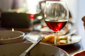 Red wine on the dining table full of food for dinner. Red wine in focus wallpaper with delicious food is blurry. The concept of healthy food.