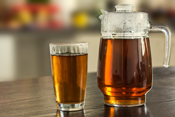 Pitcher and glass of hot black tea  background.