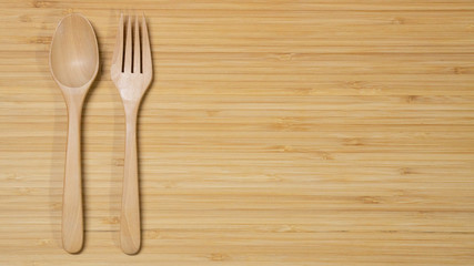 Wooden spoon and fork on wood table background. Top view. Eating food in the restaurant concept