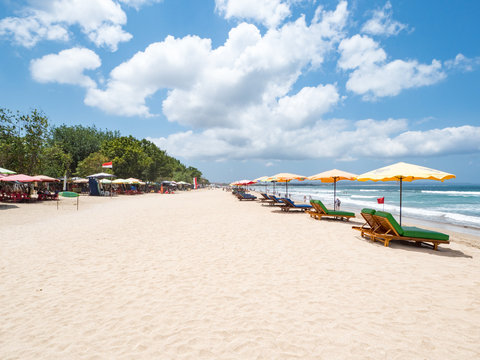 Fototapeta White sand and blue ocean. Various colorful beach umbrellas and pillows in Kuta, Bali. October, 2018