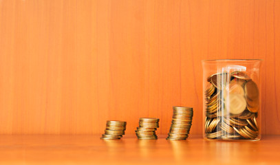 Columns of coins with jar full of coins.