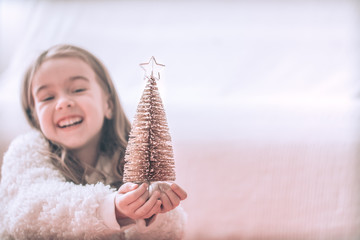 Christmas background with a little girl and a beautiful little Christmas tree