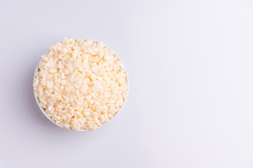 Dry uncooked white corn ingredient for Brazilian dessert sweet canjica / mungunza, white background, isolated, soft light. Festa Junina Party Brazilian Culture Concept Image.