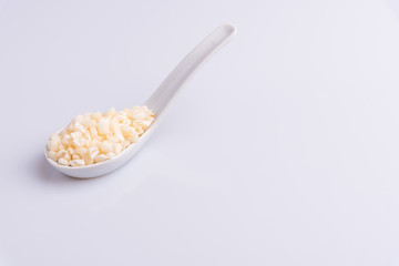 Dry uncooked white corn ingredient for Brazilian dessert sweet canjica / mungunza, white background, isolated, soft light. Festa Junina Party Brazilian Culture Concept Image.