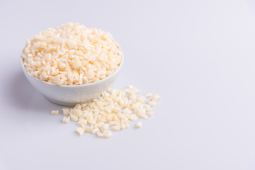 Dry uncooked white corn ingredient for Brazilian dessert sweet canjica / mungunza, white background, isolated, soft light. Festa Junina Party Brazilian Culture Concept Image.