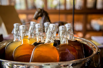 Glass bottle of cold tea in ice bucket