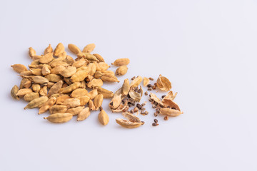 Dry Cardamom pod in a stone mortar, isolated on white background, latin term Elettaria cardamomum,  with copy space, angle view, soft light. 