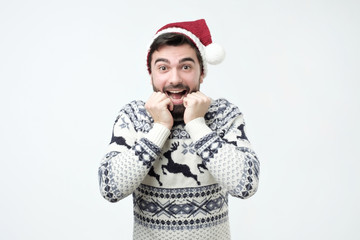 Happy hispanic man in Santa Claus cap is excited and happy.